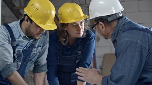 Engineers Showing Floor Plan to Foreman
