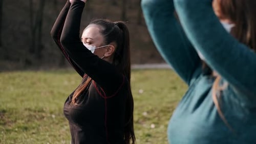 Young Women Exercise Wearing Face Masks in Park