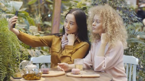 Young Beautiful Women Taking Selfie with Mobile Phone in Cafe