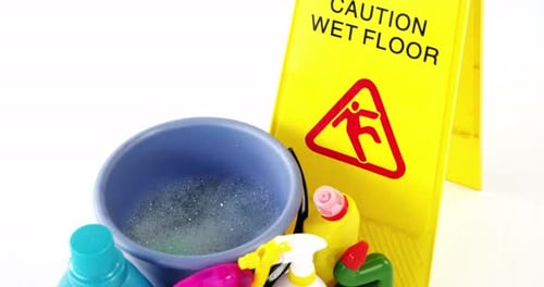 Various housekeeping supplies with caution sign
