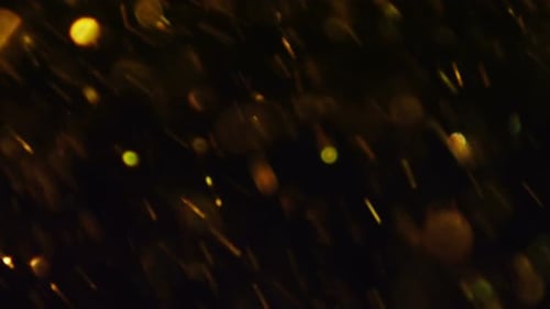 Abstract Golden Particles Floating on Dark Background