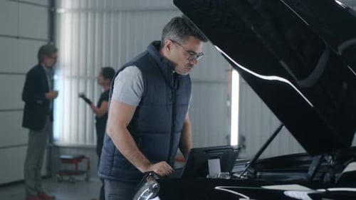 Male Mechanic Inspecting Car Engine