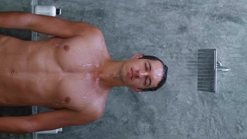 Young Adult Man Showering in Modern Bathroom