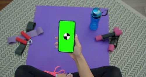 Fitness Woman Use Smartphone with Green Screen After Training at Home. Healthy Lifestyle. Stretching
