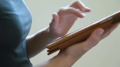 Close Up of Female Hands Using Tablet Computer Browsing Internet Working Online Researching