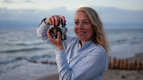 Photographer Using Slr Camera On Beach