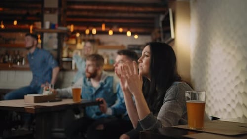 Friends and Fans Rejoice Together Emotionally Watching Football on TV in a Bar and Celebrating the