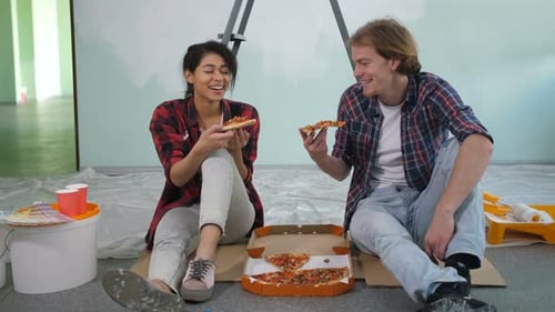 Couple Eating Pizza While Renovating Home
