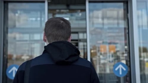 Man getting inside a building with glass walls interior