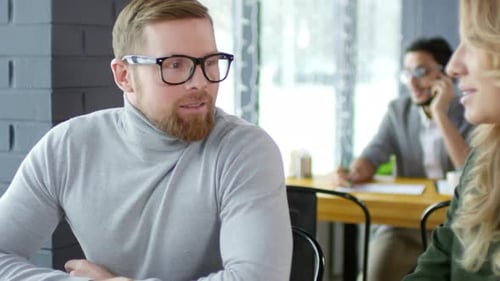 Caucasian Businessman Chatting with Female Colleague in Cafe