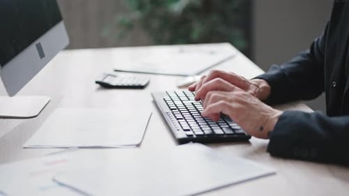 Person Typing on Keyboard in Office Workplace
