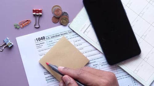 Writing Tax Due Text on a Sticky Note with Tax Return Form on Table