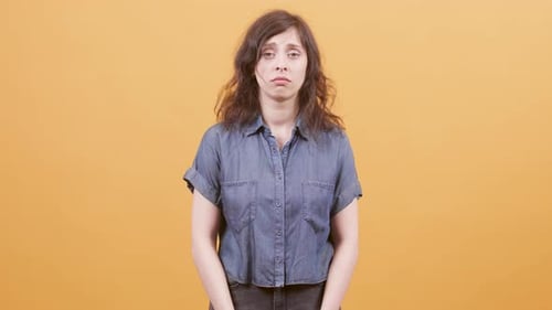 Worried Woman Standing Against Solid Background