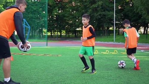 Joueur de football repoussant la balle lancée par son instructeur de football confiant et hautement qualifié