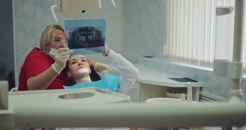 Dentist Examining X-Ray with Patient in Dental Office