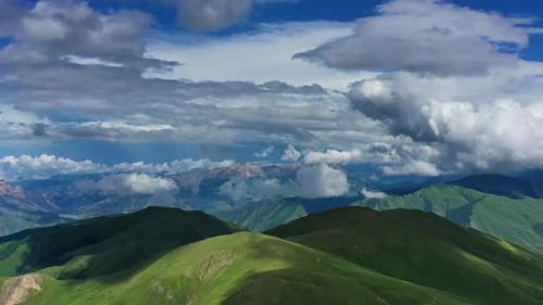 Aerial View of Green Mountains and Cloudy Skies
