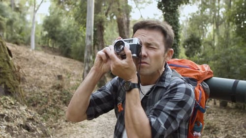 Backpacker Guy with Photo Camera Taking Pictures of Forest