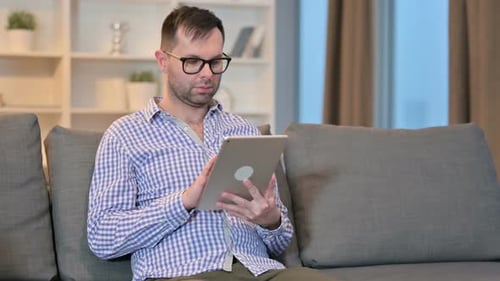 Man Using Tablet Device on Couch at Home