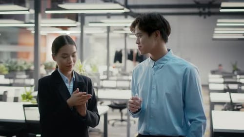 Asian Female And Male Colleagues Sanitizing Hands In Office