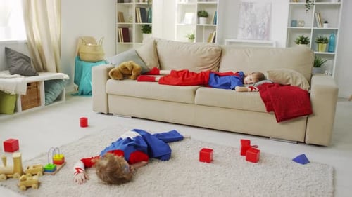 Children Dressed as Superheroes Sleeping at Home
