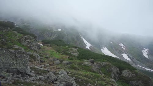 Zeitlupenaufnahme von vorbeiziehenden Wolken in Bergen