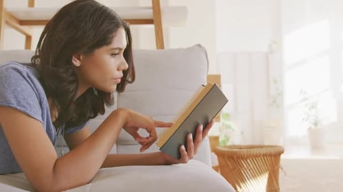Woman Enjoying a Book on Sofa at Home