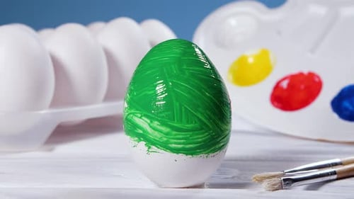 Painting Easter Eggs with a Green Brush Preparation for Spring Holiday Religious Celebration Art