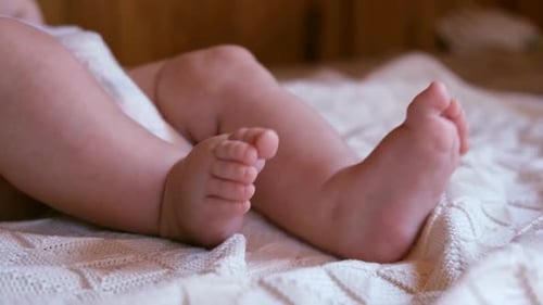 Infant's Legs and Feet on White Blanket
