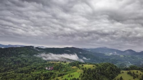 Graue Regenwolken bewegen sich über grünes ländliches Land Aerial Time Lapse