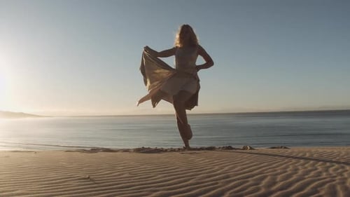 Graceful Dancer In Dress On Sand Sunlit Beach