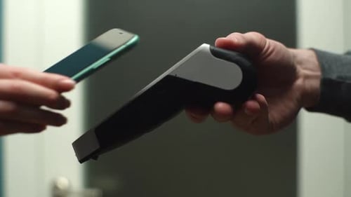 Closeup of Contactless Payment with Phone Via POSwireless Terminal at Delivery Slow Motion