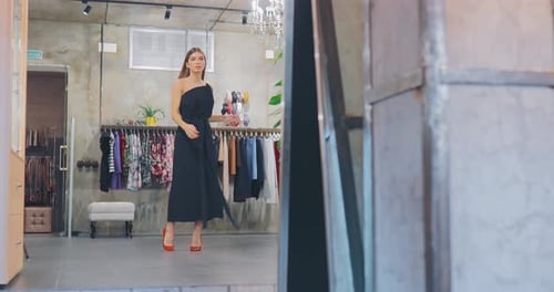 Experimentando um lindo vestido em uma boutique de roupas da moda
