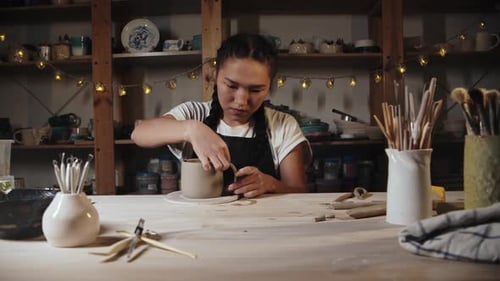 Young Adult Making Pottery in Studio