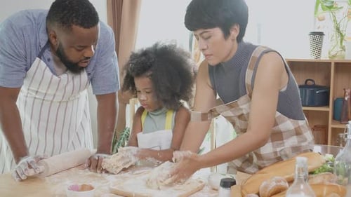Family Kneading Dough Together in Kitchen
