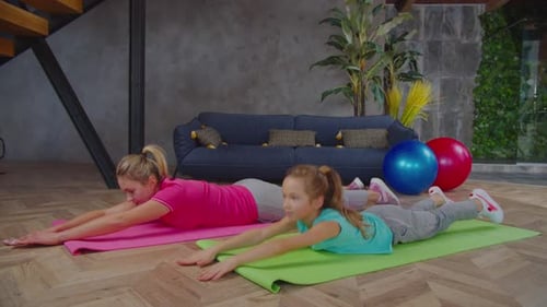 Woman and Child Exercising at Home Together