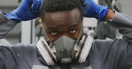 Man Putting on Protective Respirator Mask
