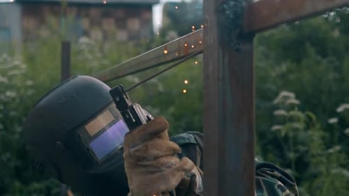 Slow Motion Handyman Stops Welding and Takes Off Mask