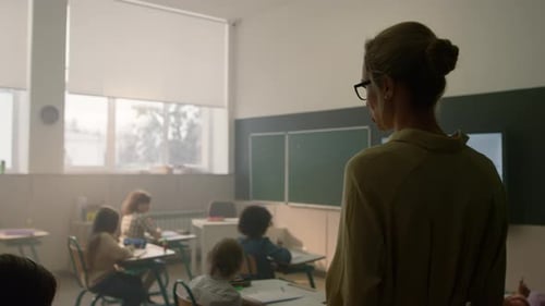 Teacher Supervising Elementary Students in Classroom