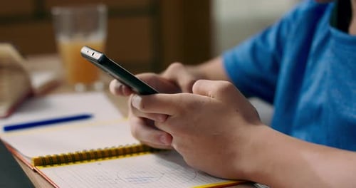 Teen Using Smartphone with Headphones at Home