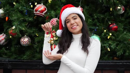 Woman Smiling in Santa Hat with Christmas Bells