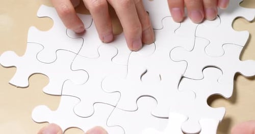 Teamwork completing white puzzle