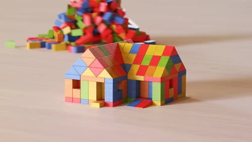 Casa de bloques multicolor de madera destruida por un tornado de ladrillos. Ruinas de madera.