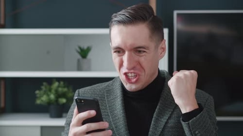 Excited Businessman Winner Celebrating Success Hold Smartphone Feel Amazed Overjoyed with Mobile
