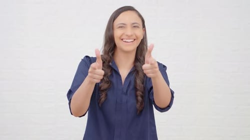Cheerful Woman Points to Camera with Finger Guns