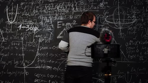 Man Teaching Math Equations on a Blackboard