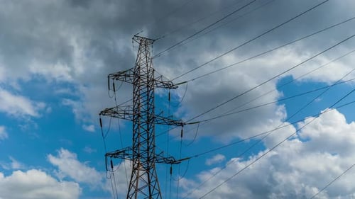 Electrical Transmission Tower against Cloudy Blue Sky