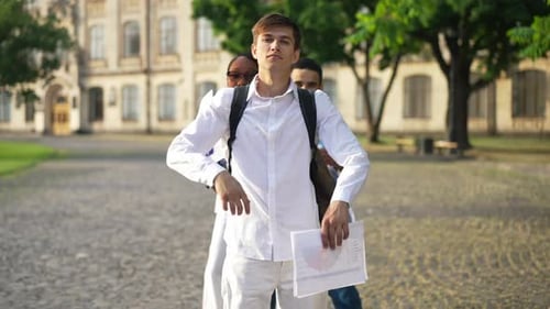 Confident Proud Caucasian Man Crossing Hands Looking at Camera with Multiethnic Groupmates Emerging