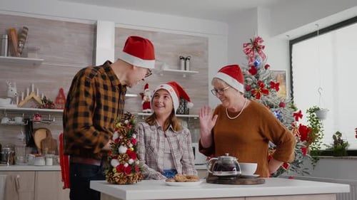 Family Celebrating Christmas and Exchanging Gifts in Kitchen