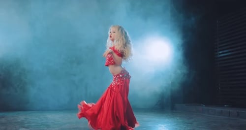 Junge Blondine tanzt orientalischen Tanz in einem schönen Anzug mit Steinen