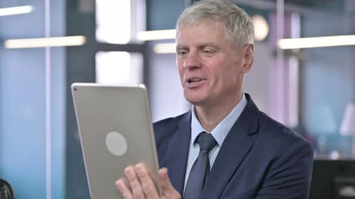 Smiling Businessman On Video Call Using Tablet